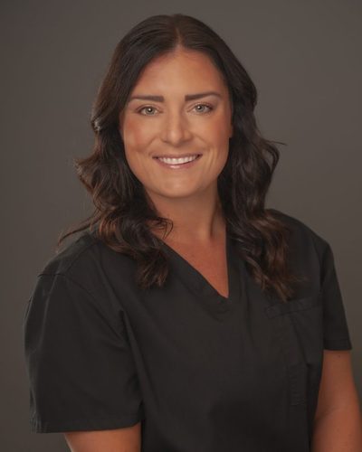 Annie Mitrisin smiling, wearing black scrubs