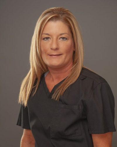 Crystal Bock smiling, wearing black scrubs