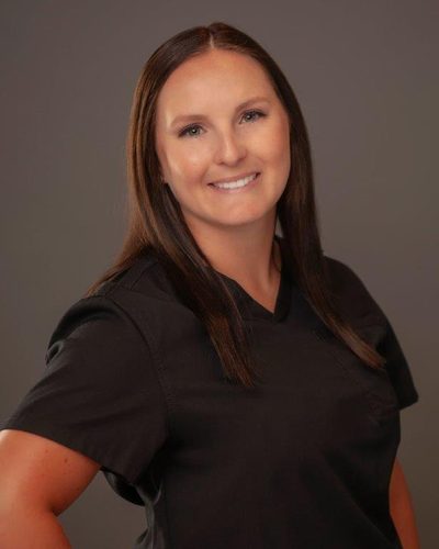 Reagan Walker smiling, wearing black scrubs
