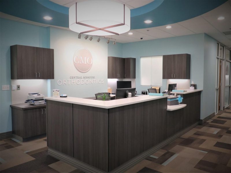 Front reception desk with the CMO logo on the wall